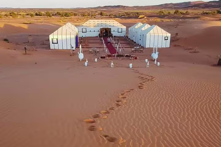 Luxury desert camp in Merzouga Erg Chebbi dunes on Morocco 12-day tour from Tangier, Sahara glamping tents