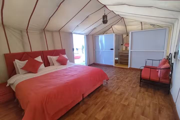 Luxurious desert tent with plush bedding in Merzouga, part of the 3-day Fes to Marrakech tour experience.