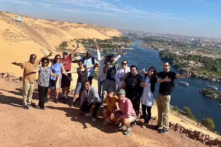 Tour group at Aswan Nile viewpoint overlooking desert and river, part of 7-day luxury Egypt cruise package