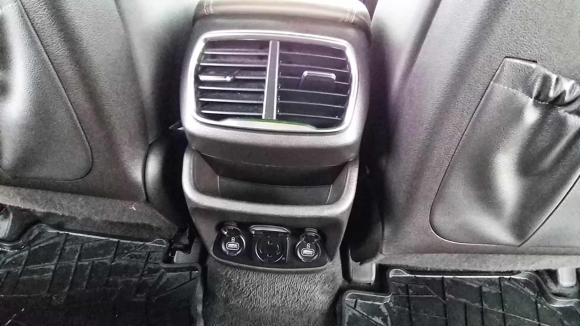 Luxurious car interior with rear air vents and charging ports for private chauffeur service and executive car hire.