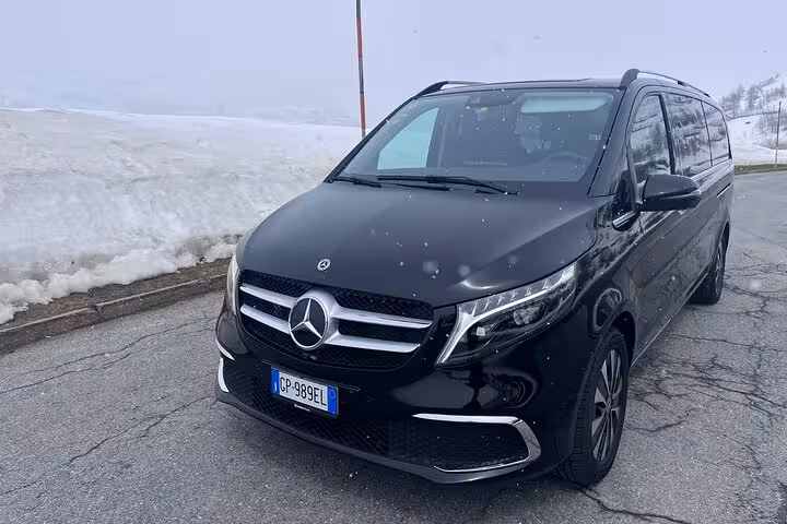 Luxury Mercedes van in snowy landscape for private Milan to Courchevel transfer, emphasizing comfort and style.