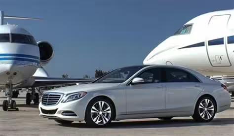 Luxury Mercedes sedan parked by private jets, illustrating premium Naples to Paestum airport transfer service