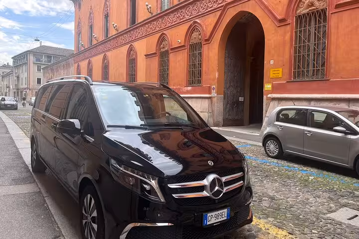 Luxury Mercedes van parked in Milan, perfect for MXP airport transfers with a scenic city backdrop.
