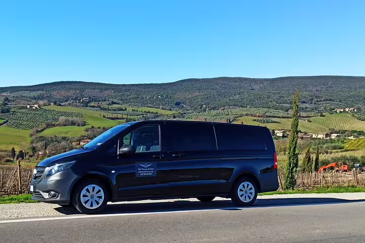 Luxury minivan parked amid rolling Chianti vineyards used for private Pisa and Chianti day tour with lunch