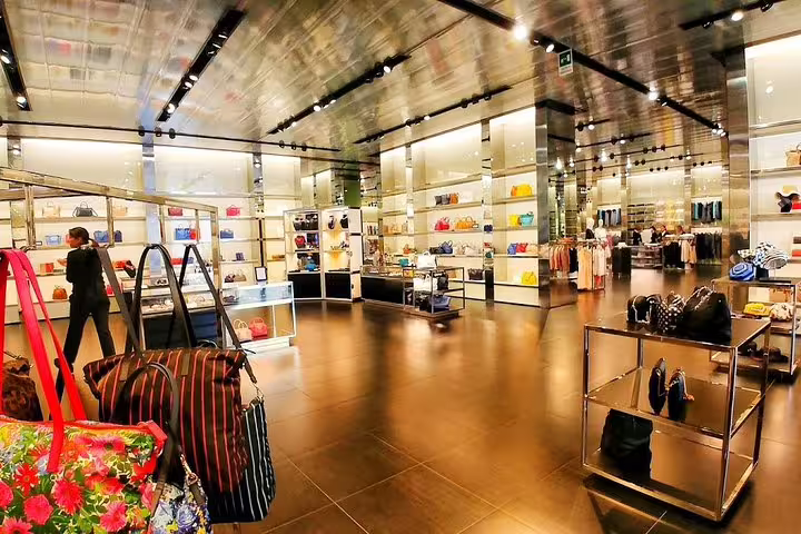 Luxury handbag and fashion boutique interior at Prada Outlet Space, visited by private chauffeur from Florence for shopping