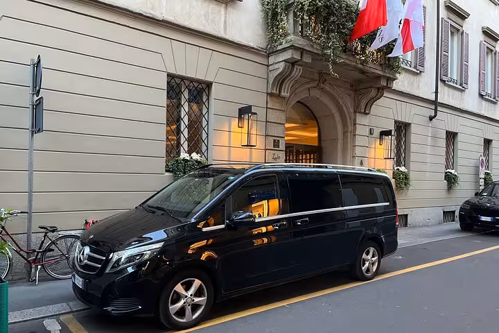 Luxury private transfer vehicle parked outside an elegant Milanese building, ideal for travel to Courchevel.