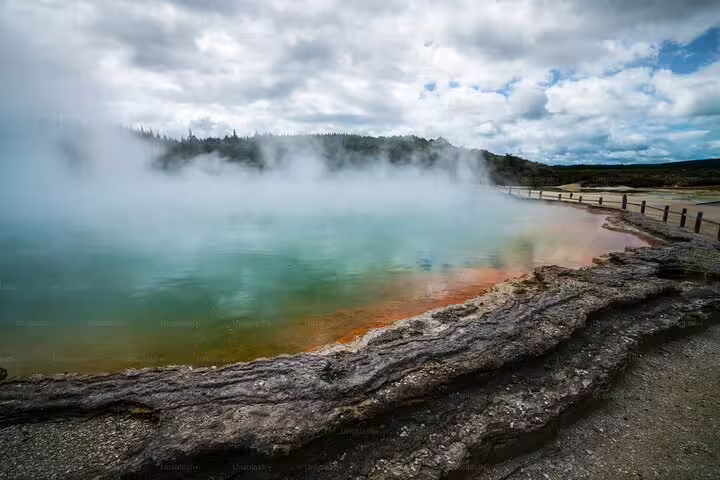 Steaming geothermal pool in Rotorua with vivid colors and natural rock formations, perfect for a luxury tour experience.