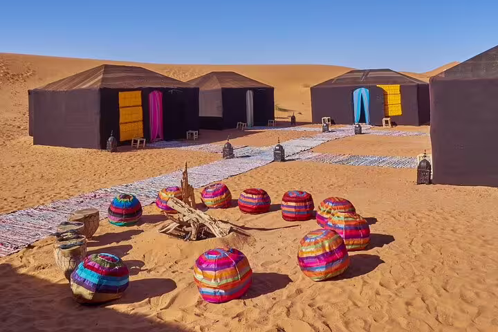 Luxury Sahara desert camp with Berber tents and colorful poufs, Morocco 12 days tour from Casablanca