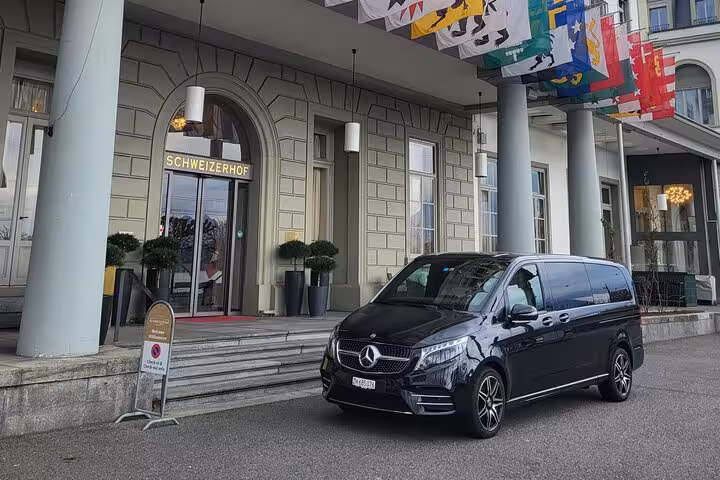 Luxury tour van parked outside Schweizerhof hotel in the Swiss Alps, perfect for private tours in Lauterbrunnen.