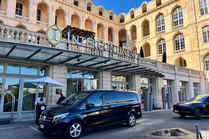 Luxury transfer vehicle outside Intercontinental hotel, showcasing private Milan to Courchevel travel service.
