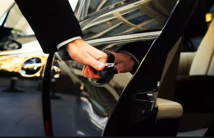 Professional chauffeur opening luxury car door for VIP private transfer between Naples and Sorrento Amalfi Coast