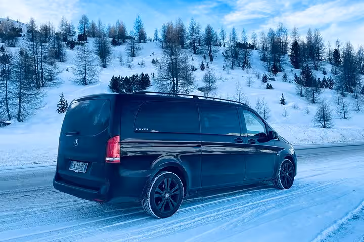 Luxury van travels through snowy alpine scenery from Cortina d'Ampezzo to Venice, offering comfort and style.