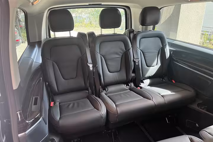 Spacious and comfortable interior of a luxury van, featuring plush leather seating for a premium travel experience.