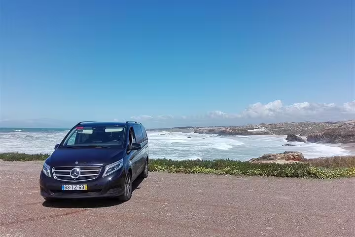 Luxury van parked along the scenic Portuguese coastline on a sunny Lisbon to Algarve tour with stunning ocean views.