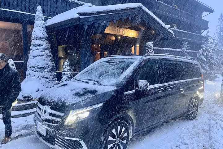 Luxury van parked in snowy Courchevel for private transfer from Milan, highlighting winter travel convenience.