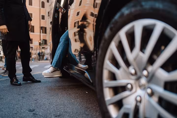 Passenger steps into luxury vehicle for private Rome to Pompeii transfer tour, highlighting comfort and style.