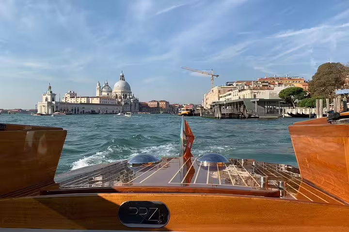 Luxurious boat ride through Venice's Grand Canal with stunning views of historic architecture and blue skies.
