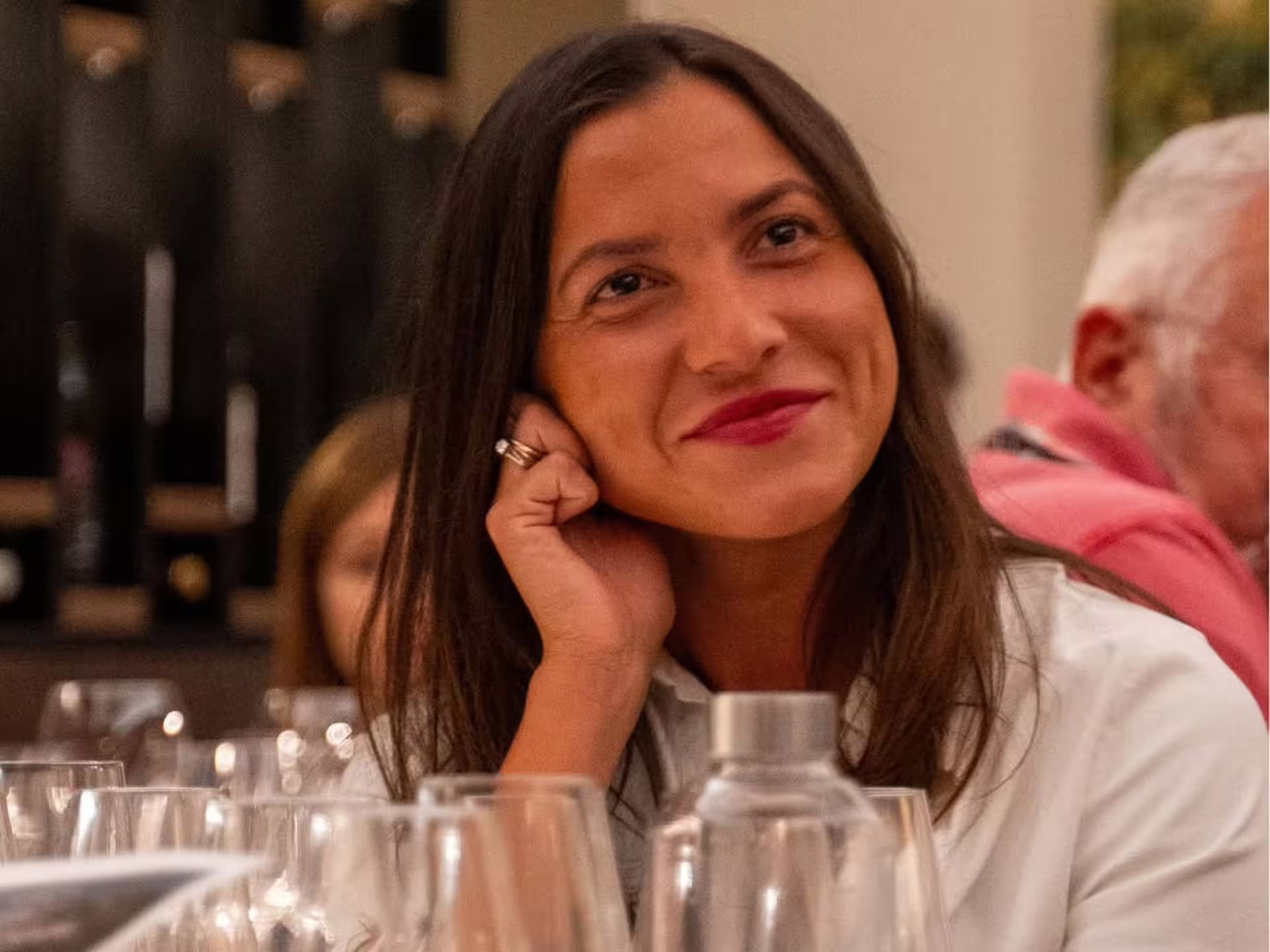 Guest enjoying luxury wine tasting in Modena city center, seated at table with wine glasses and bottles
