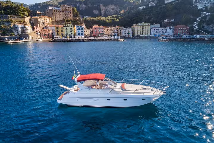 Luxurious yacht anchored near vibrant buildings on the Sorrento coast, perfect for Capri and Positano tours.
