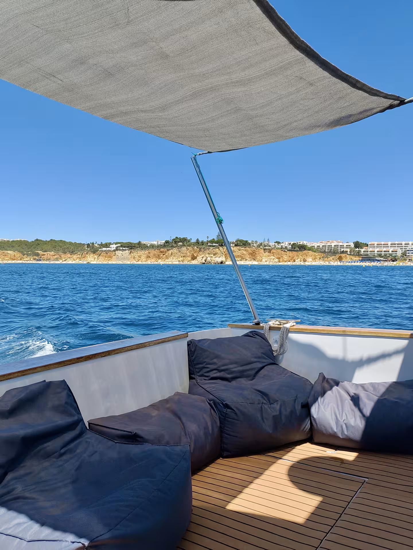 Luxurious yacht deck with shaded seating, perfect for a relaxing sunset cruise along the scenic coastline.