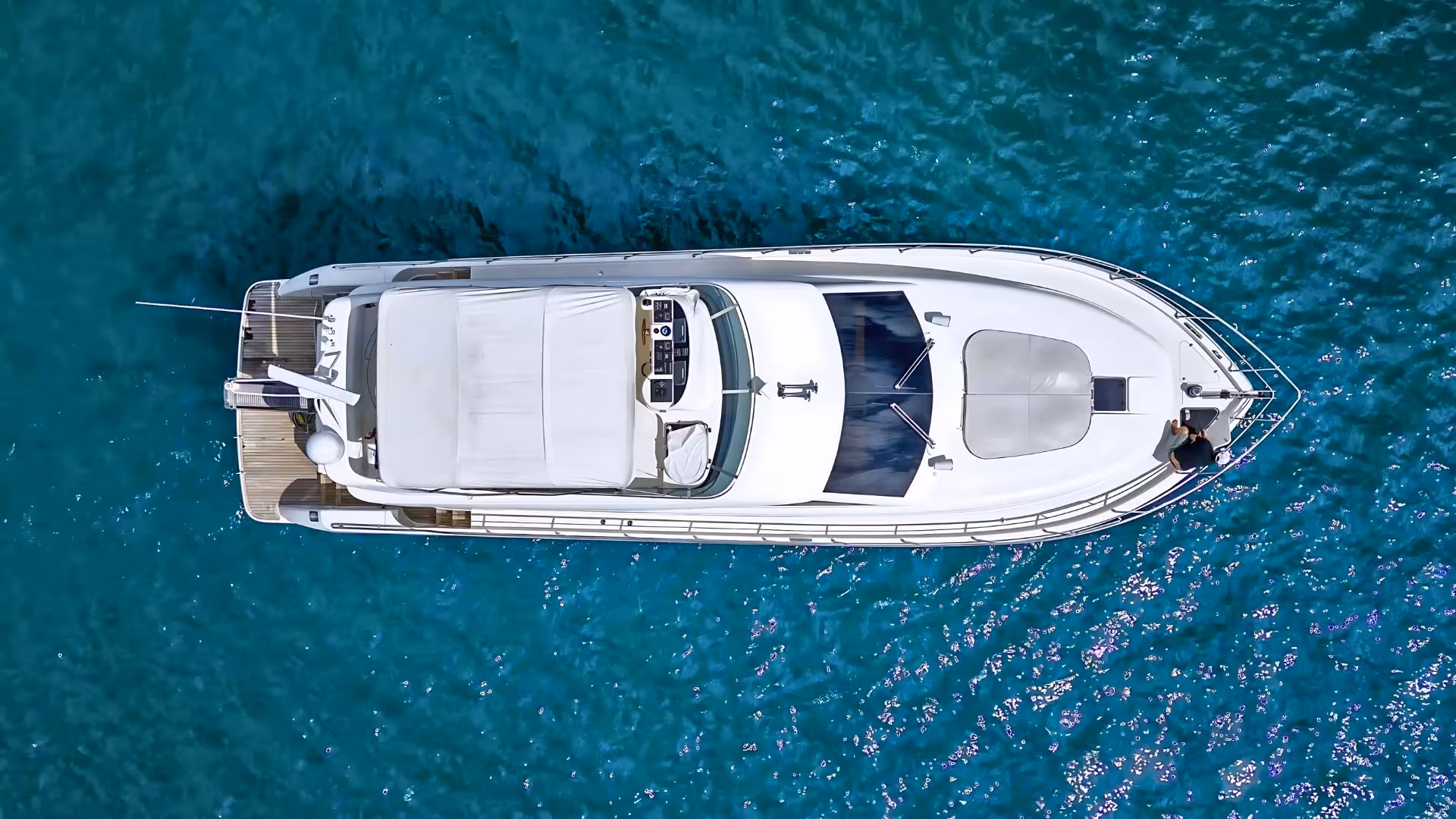 Aerial view of a luxurious white yacht cruising in the crystal-clear waters of Villasimius, ideal for private tours.