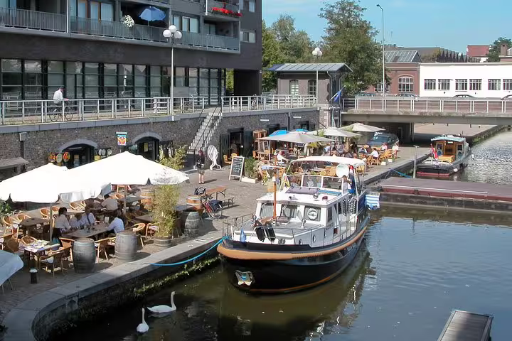 Maastricht canal terrace with boat and cafes, scenic stop on e-Scavenger hunt Maastricht self-guided tour