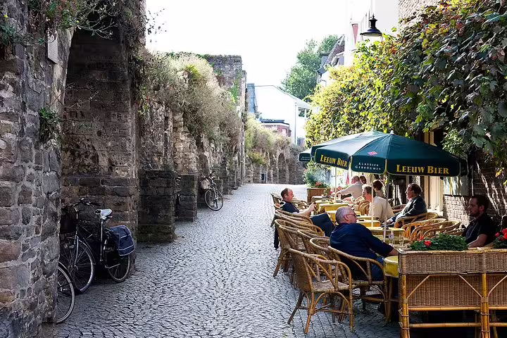 Cobbled lane by Maastricht city walls with café terrace, ideal stop on an e-scavenger hunt walking tour