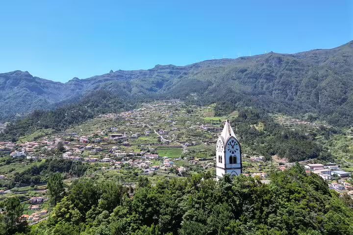 Panoramic view of Madeira's lush landscape with a quaint church tower, perfect for a guided 4x4 adventure and skywalk tour.