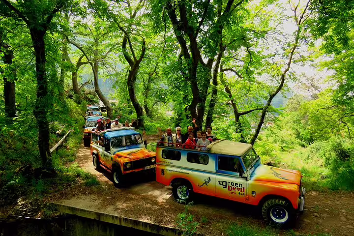 Tourists enjoy a thrilling 4x4 ride through lush Madeira landscapes, offering views of skywalks and vineyards.