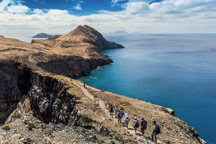 Hikers exploring dramatic coastal cliffs with stunning ocean views on the Madeira east coast tour.