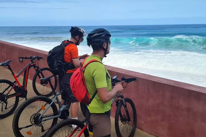 Cyclists enjoy breathtaking ocean views during a guided e-bike tour along Madeira's stunning north coast.