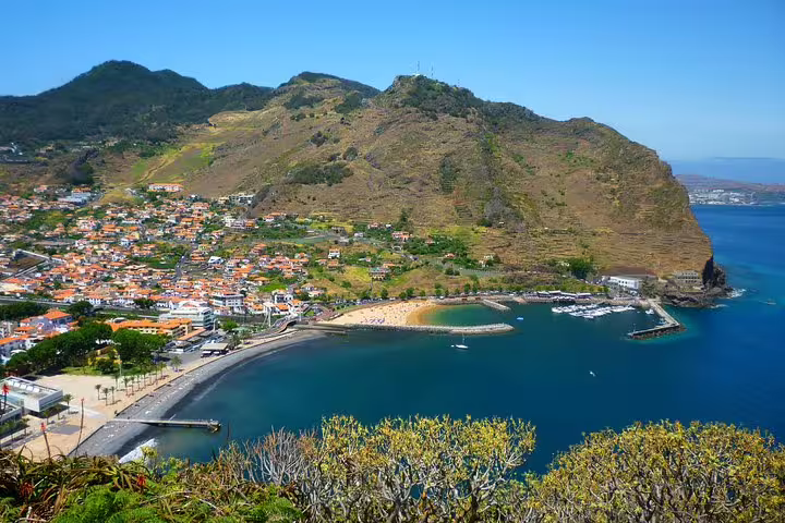 Breathtaking coastal view of Madeira Island showcasing a vibrant seaside village and lush hillsides.