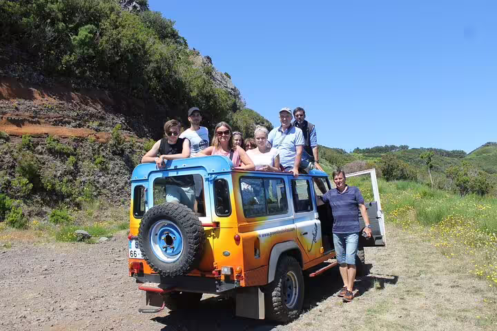 Group enjoying scenic Madeira jeep tour through lush landscapes, part of Skywalk Wonders & Wine Delights experience.
