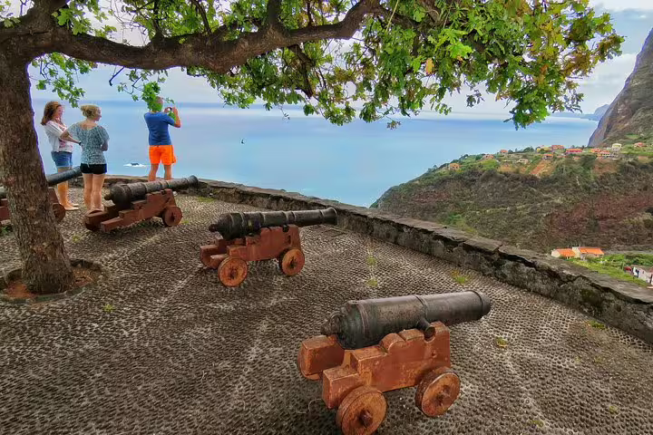 Tourists admire stunning ocean views from a historic cannon viewpoint on the Madeira Peaks 4X4 Full-Day Adventure Tour.