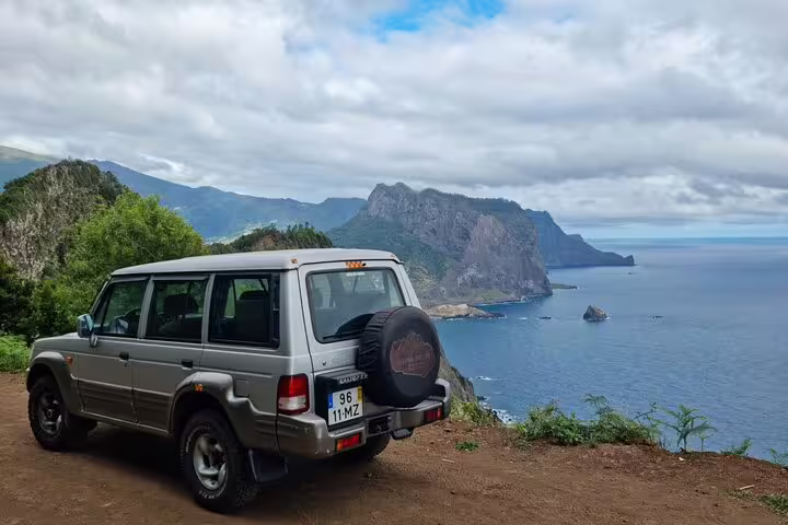 4x4 vehicle overlooking scenic coastal cliffs on Madeira's Porto da Cruz to Machico hiking route, offering breathtaking views.