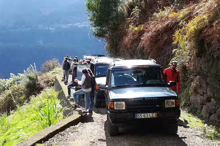 Adventurers explore Madeira's east coast on a rugged Land Rover safari tour through lush mountain trails.