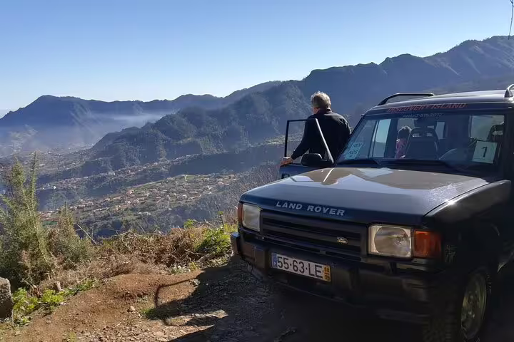 Traveler enjoys panoramic mountain vistas from a Land Rover during an east Madeira safari adventure.
