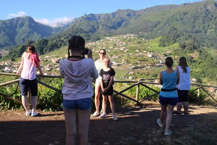 Visitors enjoy breathtaking views of Madeira's lush landscapes, capturing memories on a scenic skywalk tour.