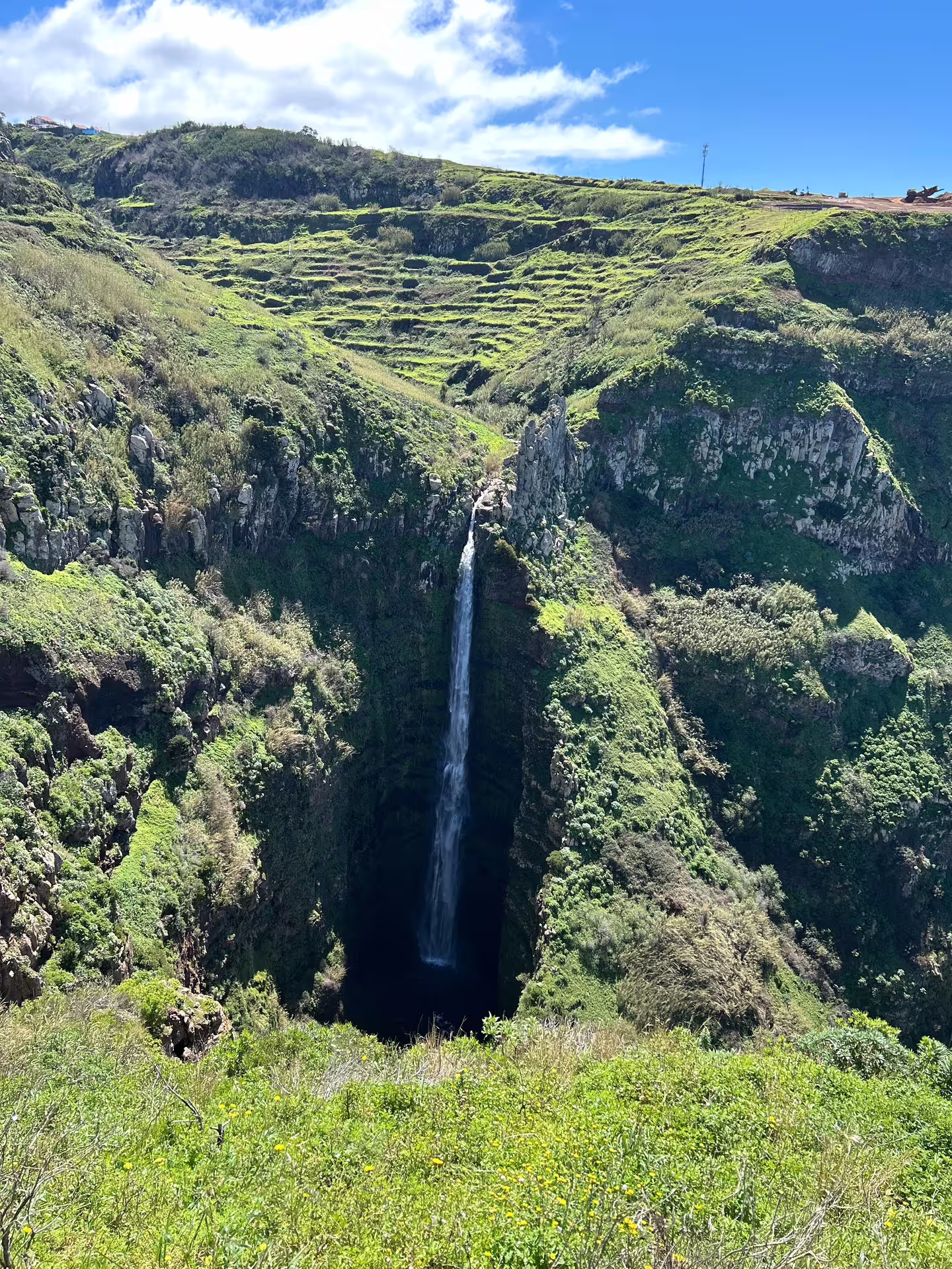 Scenic Madeira waterfall cascading into a lush green canyon, perfect for a private, comfortable exploration tour.