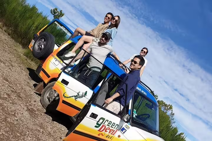 Group enjoying a scenic Madeira West tour in an open-top jeep, exploring Enchanted Terraces and Fanal Unesco site under a clear sky.