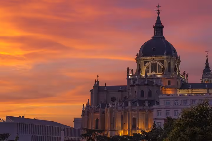 Stunning sunset over Madrid's iconic Almudena Cathedral, highlighting the city's architectural beauty.