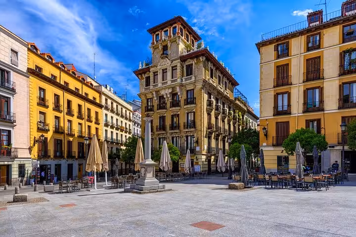 Charming Madrid square with historic architecture, outdoor cafes, and vibrant atmosphere on Lisbon to Madrid private transfer.