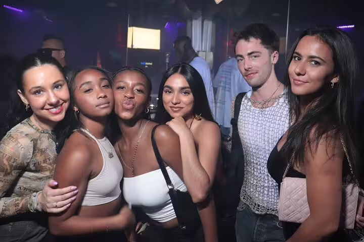 Group of friends enjoying a vibrant night out during a Madrid pub crawl tour, capturing the lively party atmosphere.