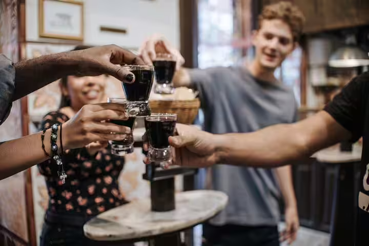 People clinking glasses of wine in a lively Madrid tapas bar, enjoying a cultural food tour and authentic Spanish experience.