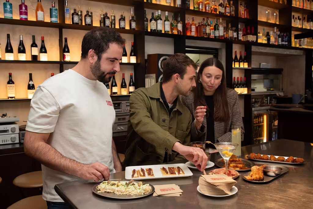 Guests enjoying tapas and wine at a stylish Madrid bar on the Authentic Madrid - Food, Wine & Culture Tour.