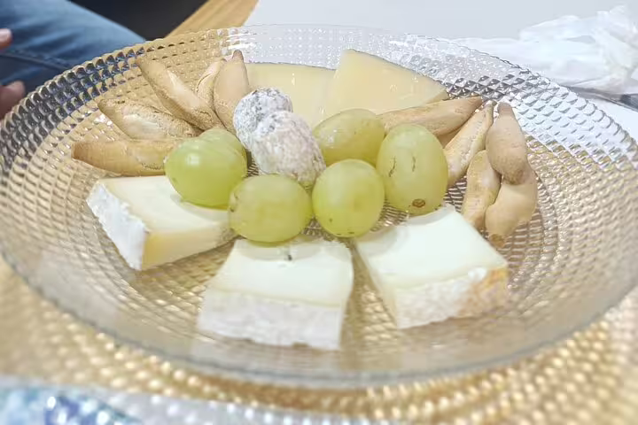 Elegant cheese platter with grapes and breadsticks on Madrid Wine Tour, showcasing local flavors.