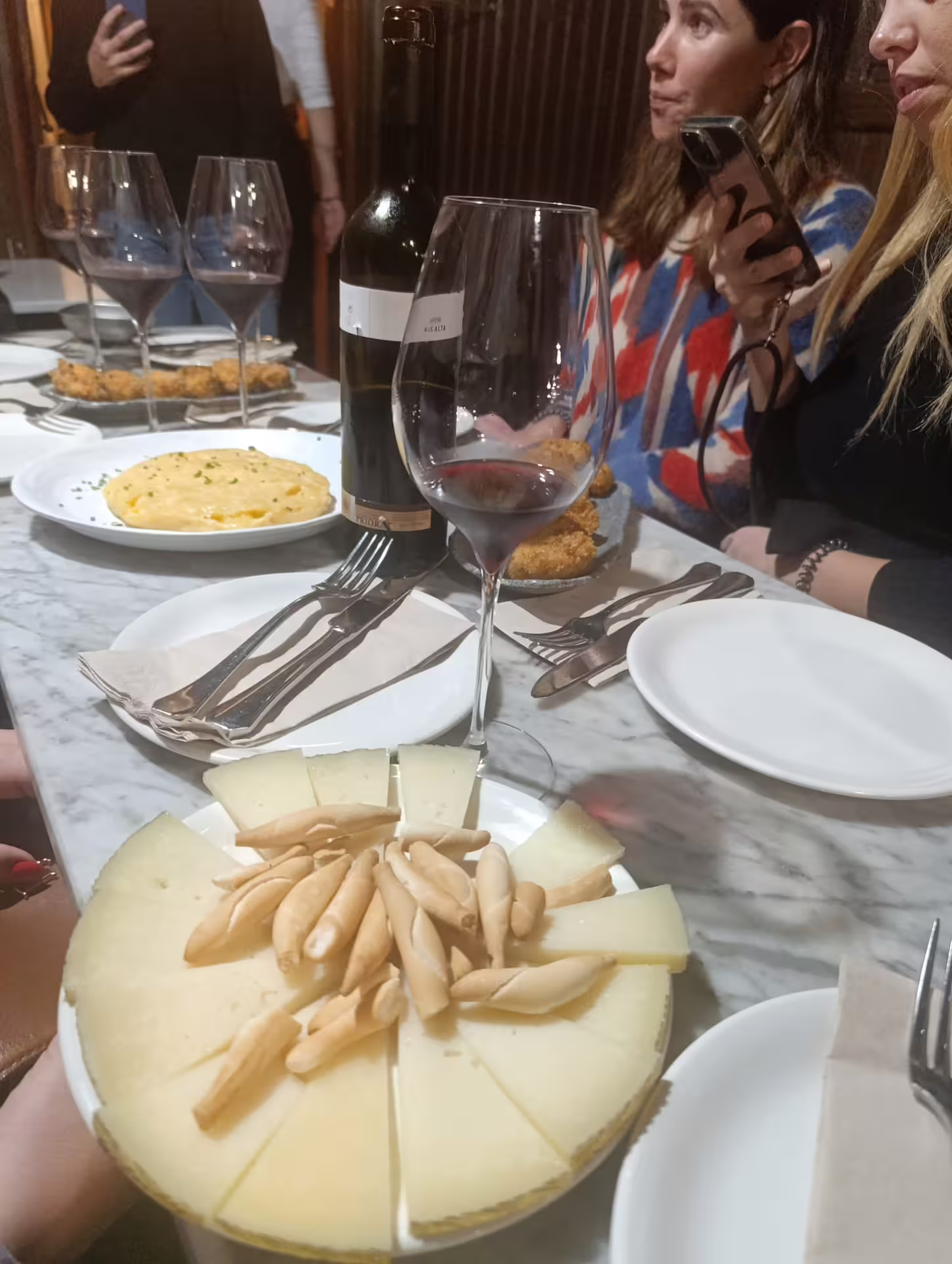 Cheese platter with breadsticks alongside wine glasses during a Madrid city wine and pairing tour.