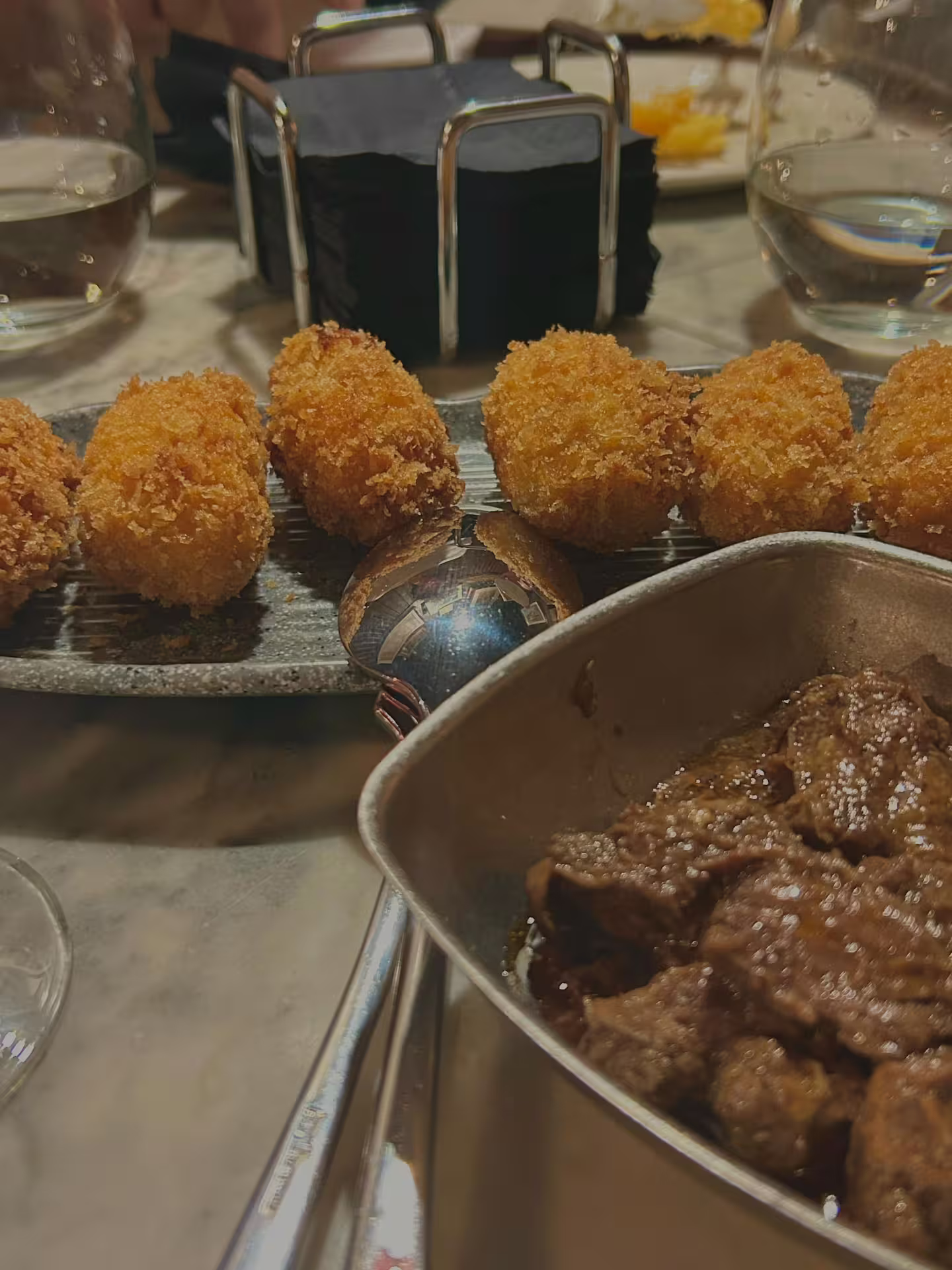 Delicious tapas featuring crispy croquettes and savory meat, paired with wine on a Madrid city culinary tour.