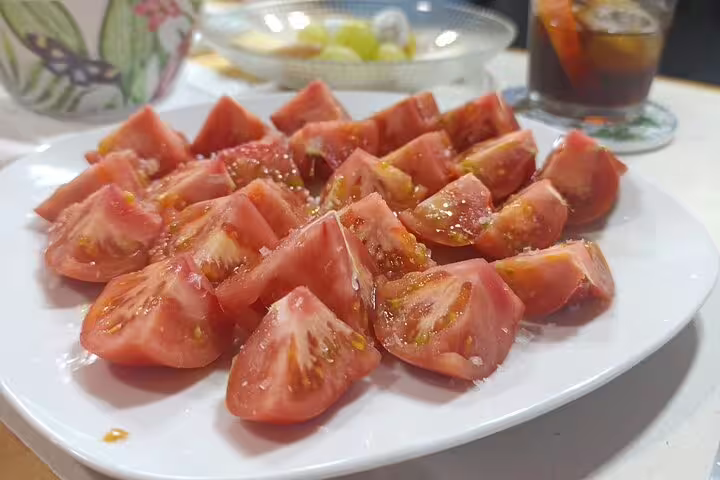 Freshly sliced tomatoes seasoned with salt, served alongside drinks on the Madrid Wine and Food Tour.