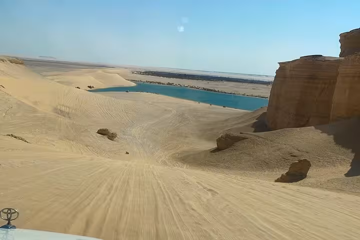Magic Lake Fayoum Oasis with golden sand dunes and 4x4 tracks, scenic desert safari near Whale Valley